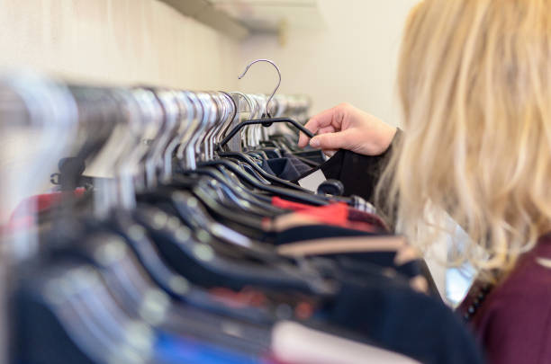 istock Female shopper searching through garments 647309256
