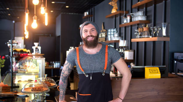 istock Bearded and tattooed hipster coffee shop owner posing 647312830