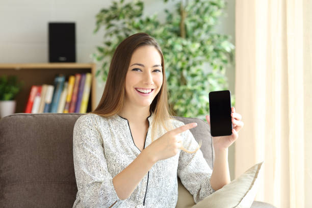 istock Woman showing phone screen at home 647319662