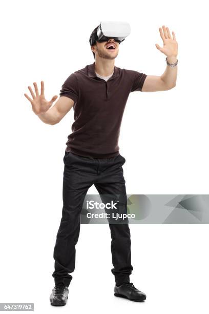 Amazed Man Experiencing Virtual Reality Through A Headset Stock Photo - Download Image Now