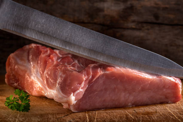 istock Cutting raw pork muscle with knife over wood 647322254