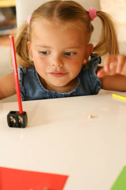 istock Young girl sharpening the pencil. 647336450