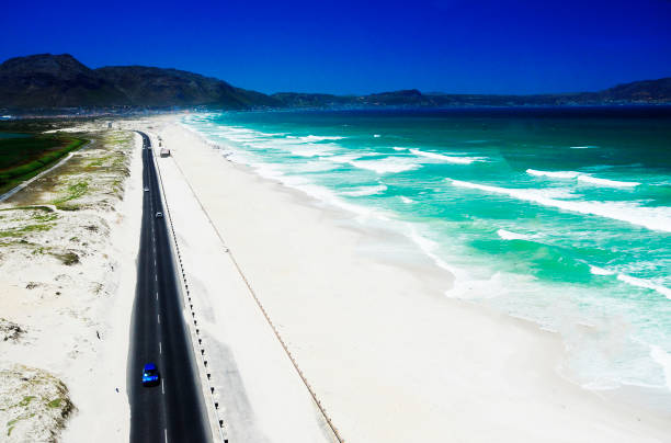 istock Coastal road along white sand beach and sea 647338480
