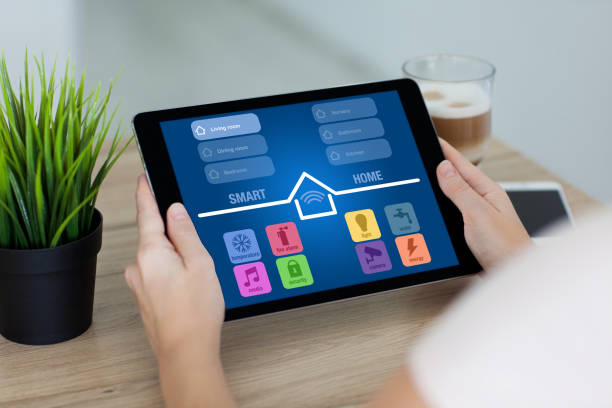 istock woman holding tablet with app smart home screen in room 647345610