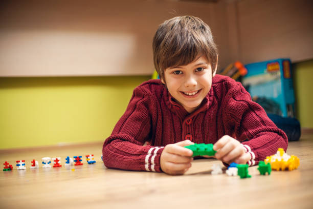 istock Cute little boy playing with cubes on the floor 647348214