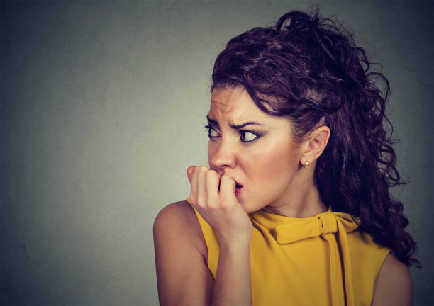 istock scared nervous woman biting fingernails craving for something 647348242