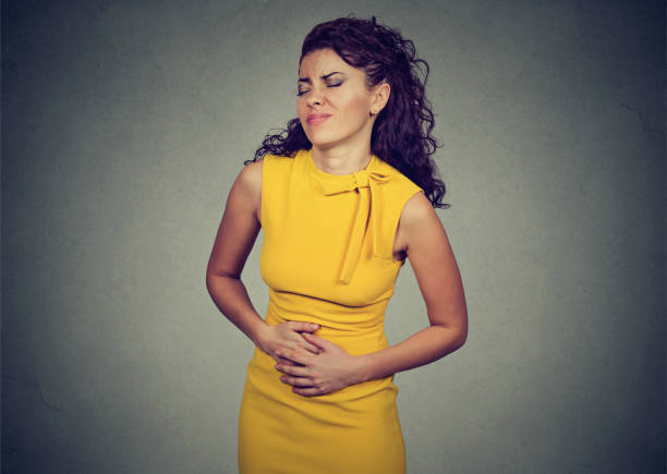 istock woman with hands on stomach having pain 647349116
