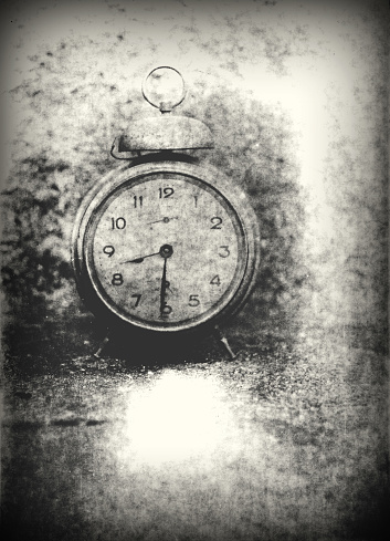 Old photo of the alarm clock - grained, scratched, overexposure and underexposure, unfocused, overall poor