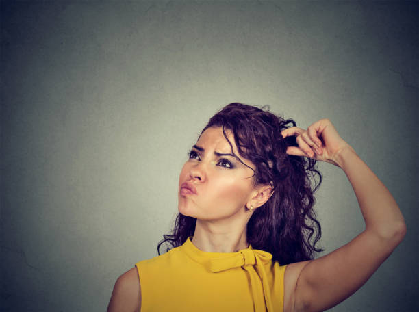 istock confused thinking young woman bewildered scratching head 647352502