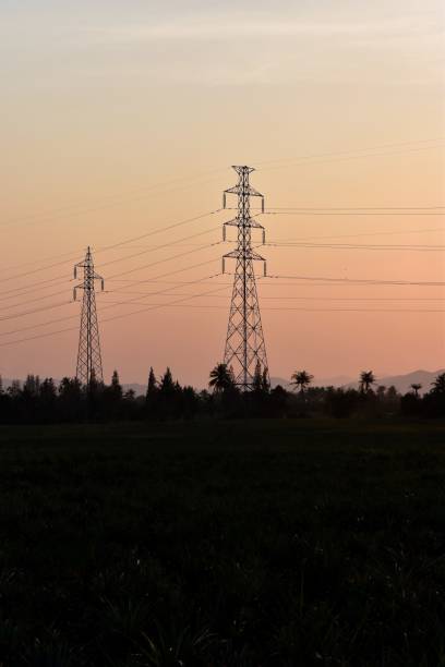 istock High voltage post or  tower in field silhouette in sunset background 647352698