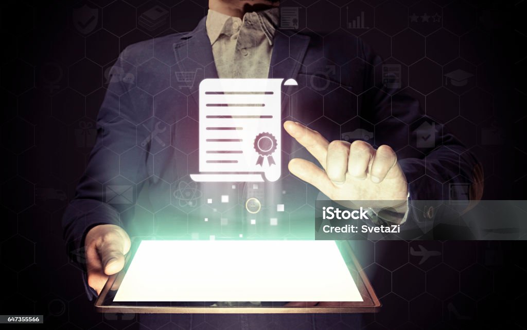 Concept of online learning. Concept of online learning. Man  touches to certificate icon  (diploma). He  holds tablet pc, that contains a many different online services. Certificate Stock Photo