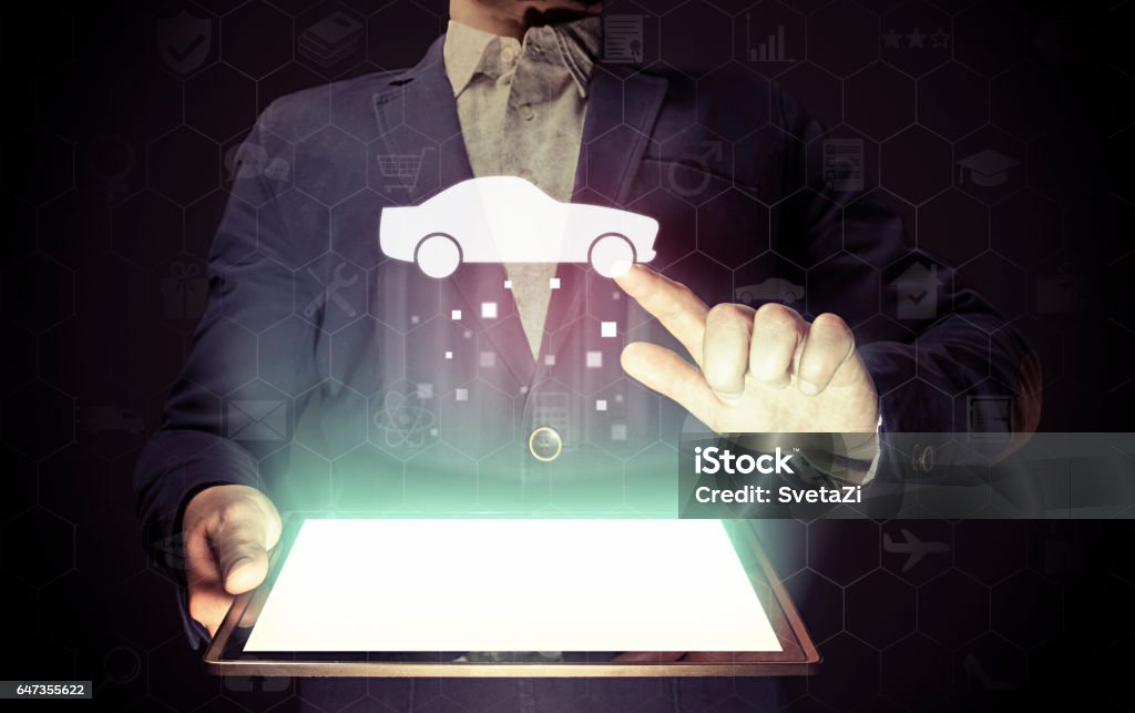 Car searching service. Image of a man with tablet in his hands. He looking for a car for buying or for rent, using online searching service. Car Stock Photo