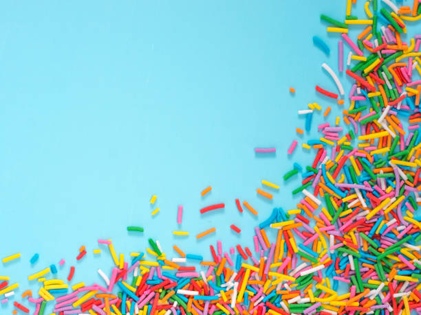 istock Border frame of colorful sprinkles on blue background 647358104