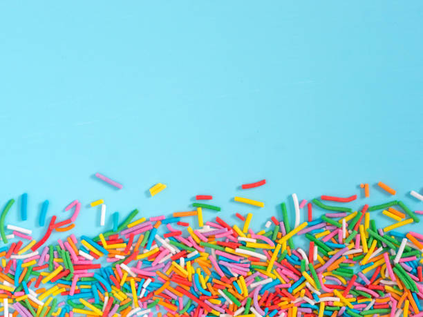Border frame of colorful sprinkles on blue background