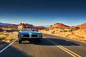 man driving vintage car through desert