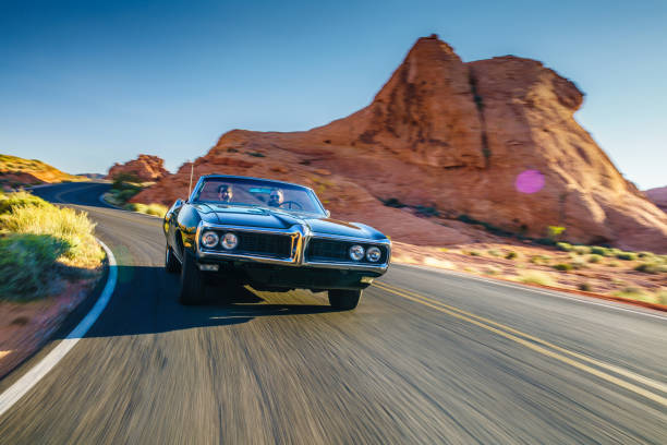 couple driving together in cool vintage car through desert couple driving together in cool vintage car through desert at high speed. hot rod car stock pictures, royalty-free photos & images