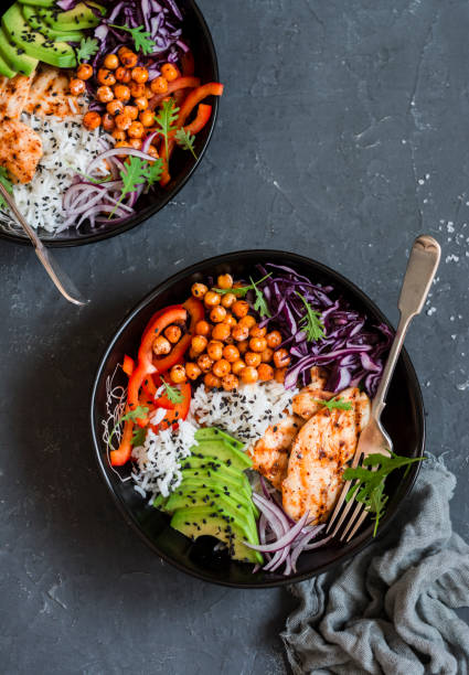 istock Grilled chicken, rice, spicy chickpeas, avocado, cabbage, pepper buddha bowl on dark background, top view. Delicious balanced food concept 647362724