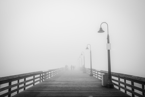 Silhouettes of people in the fog on the Imperial Beach pier.