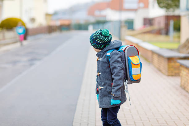 Grandmother and grandson walking side by side outdoors, enjoying time together while wearing backpacks