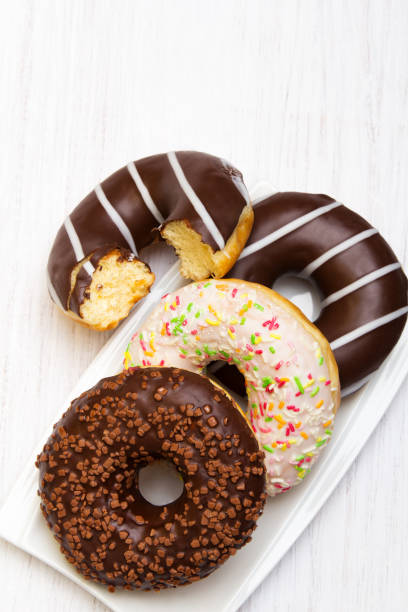 istock Tasty donuts with icing and chocolate on white wooden background 647369138