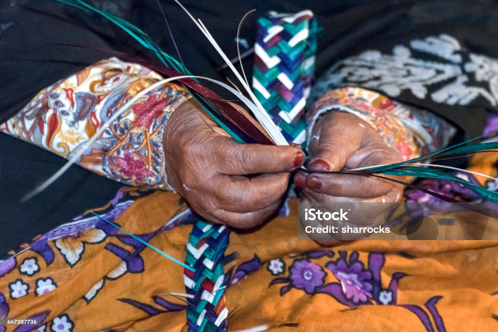 Arab woman weaving Hands of an arabic artisan woman weaving with lengths of reed United Arab Emirates Stock Photo