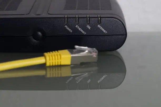 detail of a wlan internet router with a yellow twisted pair cable