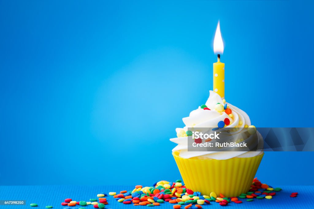 Yellow birthday cupcake Birthday cupcake with a single yellow candle Birthday Cake Stock Photo