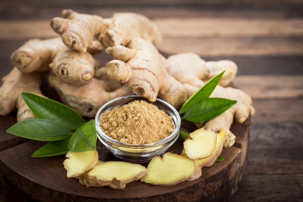 Ginger root and ginger powder in the bowl stock photo