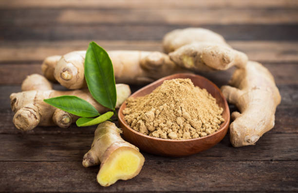 Ginger root and ginger powder in the bowl stock photo