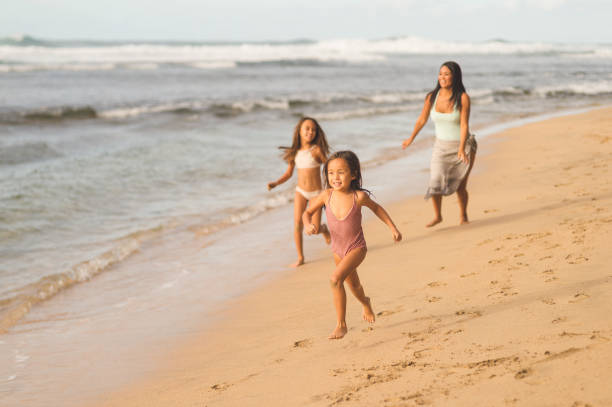 Hawaii family vacation on beach Family playing on beautiful Hawaii beach swimwear bikini top bikini bikini bottom stock pictures, royalty-free photos & images