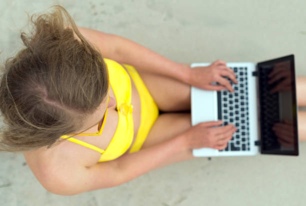 istock Girl working on laptop on the beach. Top view. 647409576