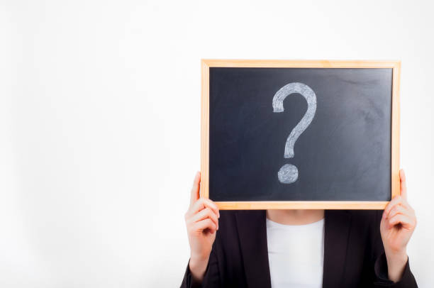 istock Woman holding chalkboard with question mark on it before face. 647409586