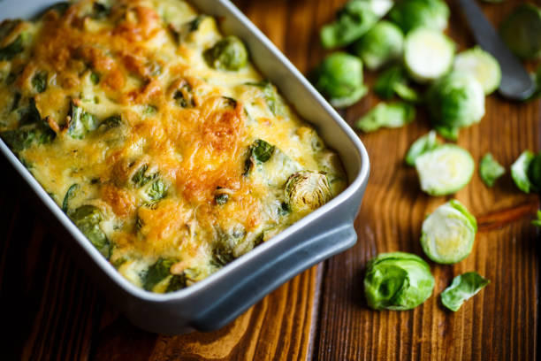 coles de bruselas al horno en salsa de queso - col de bruselas fotografías e imágenes de stock