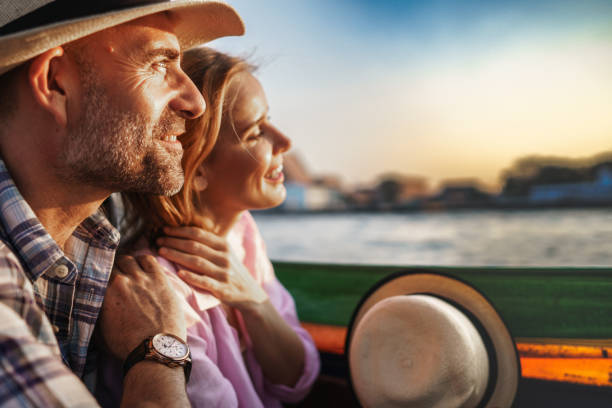 Middle-aged man and his companion handsome blond lady on a boat ride in Bangkok stock photo