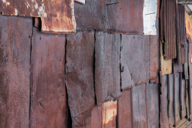 istock Backdrop of the barn covered with old rusty tin sheets and slate, at an angle, background 647430326