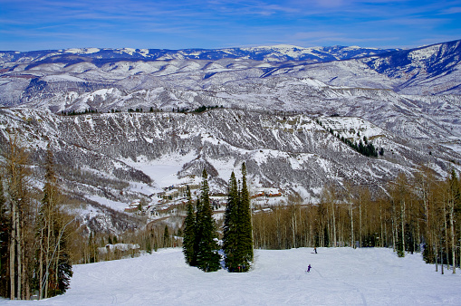 The Rocky Mountains offer a panoramic view to skiers on a sunny day in Colorado.