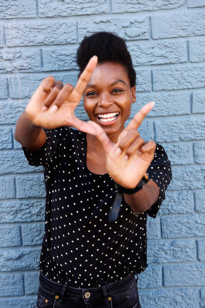 istock Smiling african woman making frame with fingers 647437246