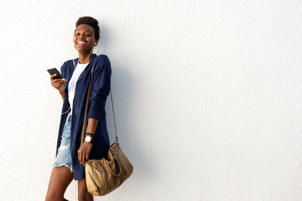 istock Cheerful young black urban lady with mobile phone 647437302