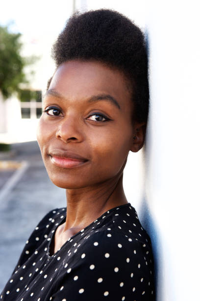 istock Attractive young black woman standing by a wall 647437360
