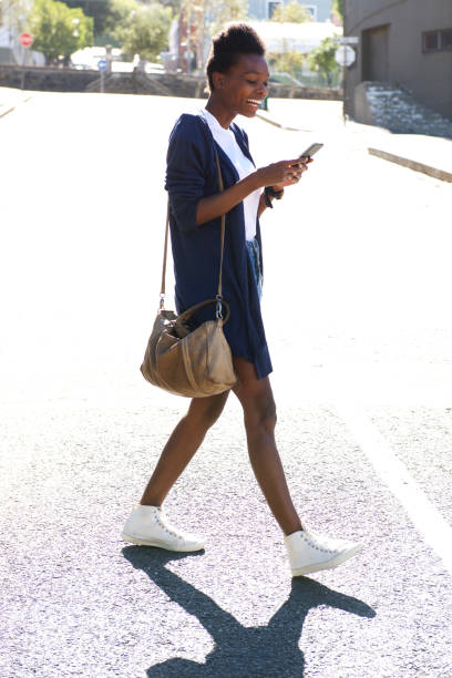 istock Young african woman using mobile phone on the street 647437700