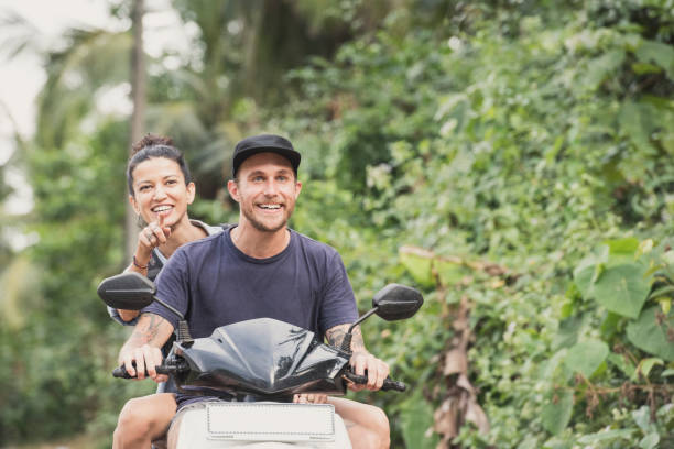istock Cheerful couple on moped with woman pointing 647441148