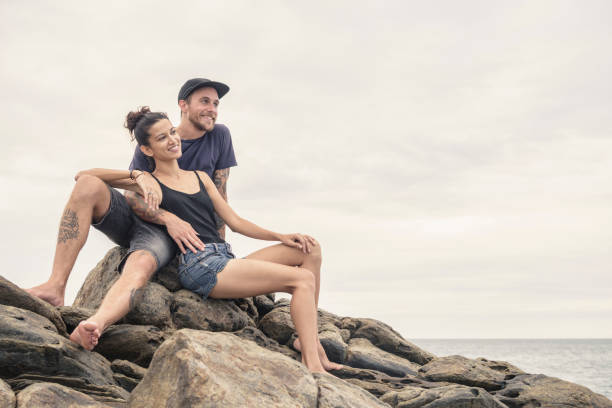 Romantic couple on vacation in Sri Lanka, woman leaning against man, smiling and looking away