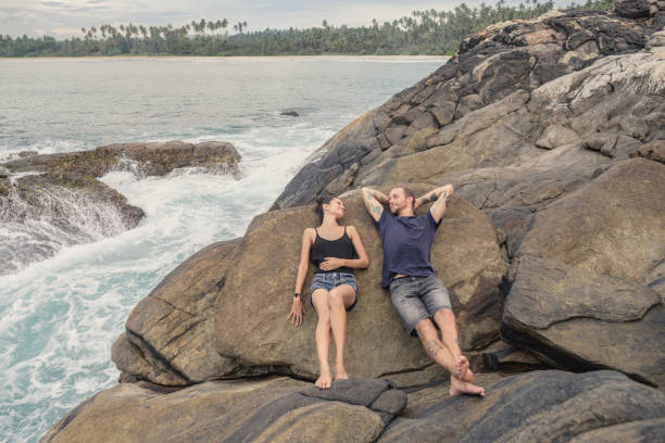 Mid adult couple lying on rocks relaxing