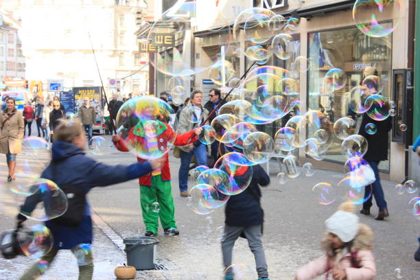 Basel, Switzerland; 25 Feb, 2017. Street entertainer creates big bubbles using soapy water for children.