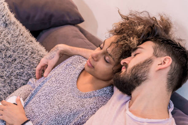 istock Happy couple resting on couch in light room 647449524