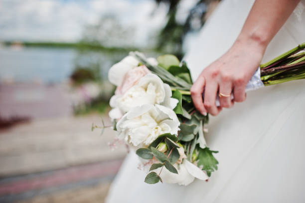 istock Elegance white wedding bouquet at hand of bride. 647451770