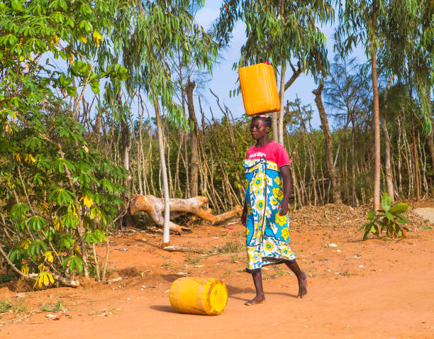 MALINDI, KENYA - January 24, 2017: A young woman is carrying water from a nearest hydrant to her home. stock photo