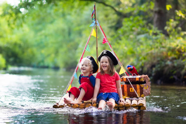 istock Kids playing pirate adventure on wooden raft 647467368