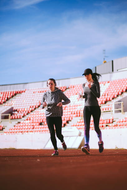 istock Young Women Jogging On Sunny Morning At Stadium 647470500