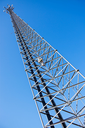 Climber ascending the cellular tower. Wisconsin, USA.
